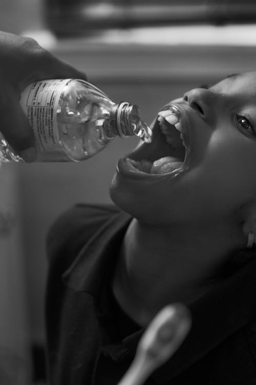 Shea brushing Zion's teeth with bottled water in her bathroom